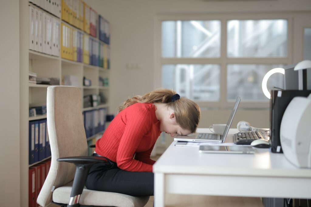 Tired woman at desk - 12 Tips to Sleep Better - Sofiaspencil.com